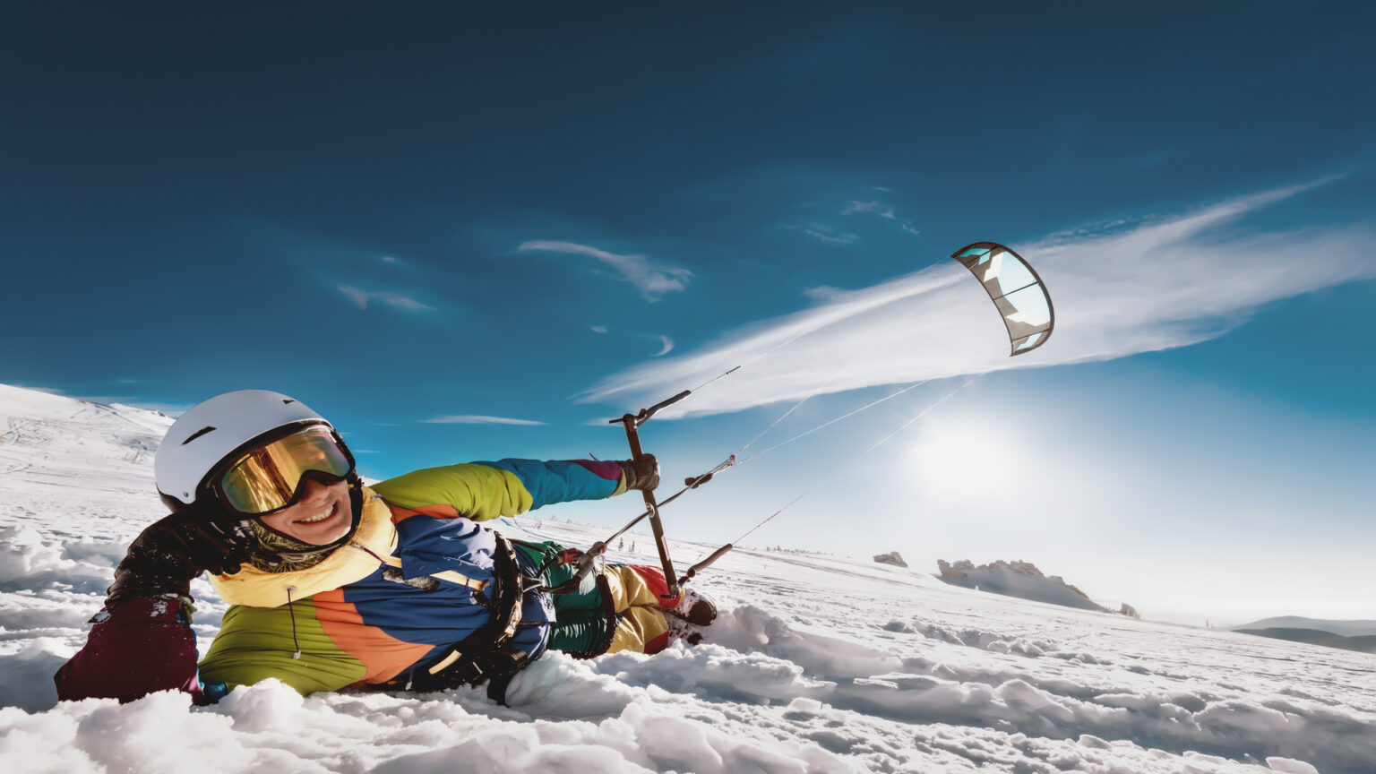 Snowkiteur en action avec son aile et son harnais de kitesurf sur la neige