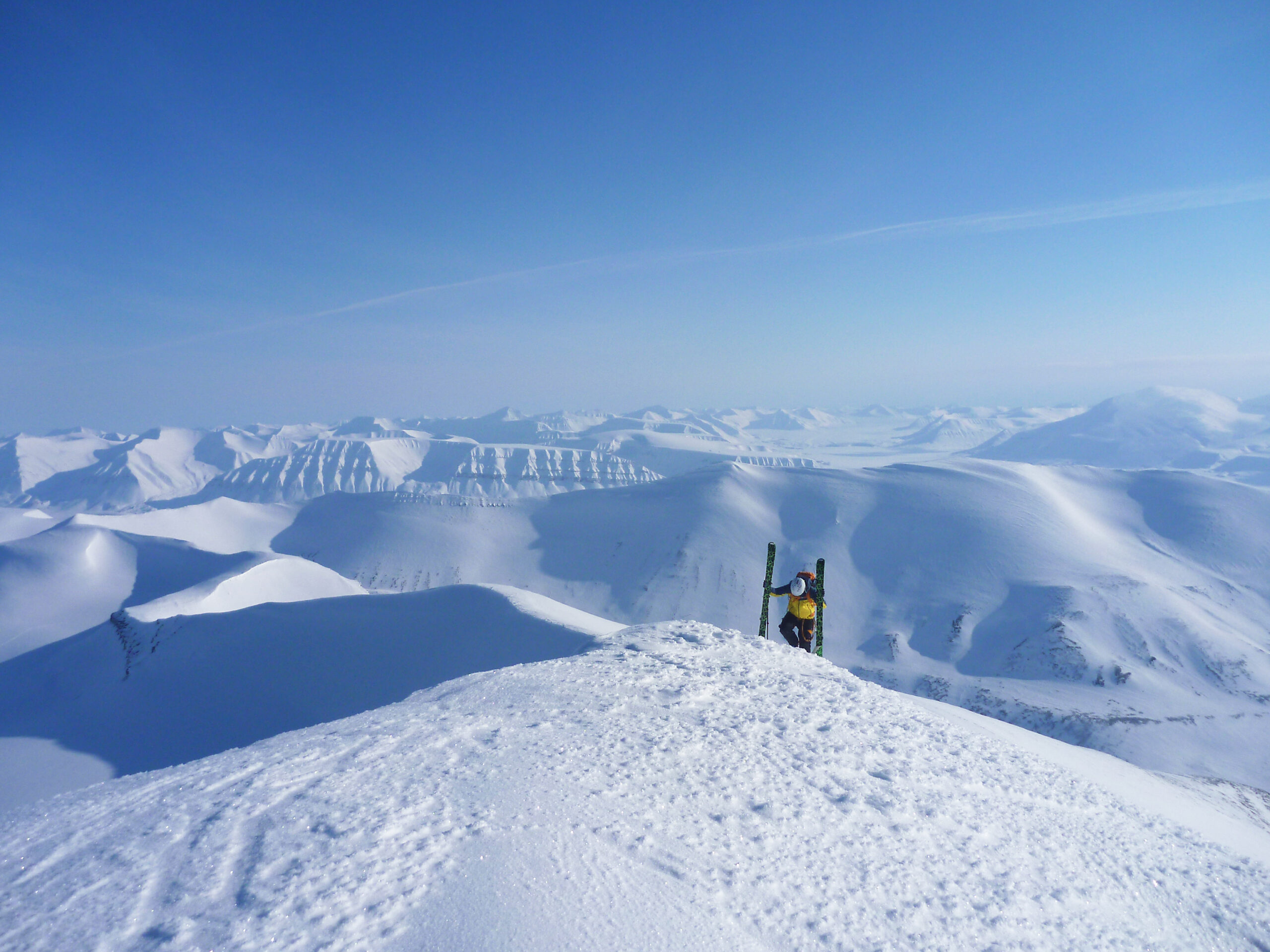 Rider de snowkite au sommet, skis plantes dans la neige, panorama arctique